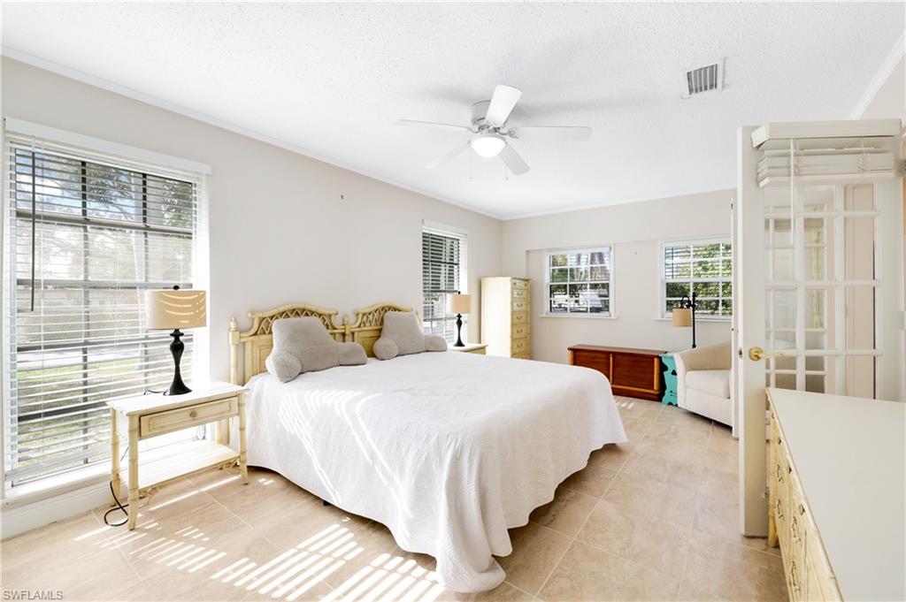 3461 Lakeview Drive Naples, FL 34112 - Photo 24 of 32 a bedroom with a large bed and a large window
