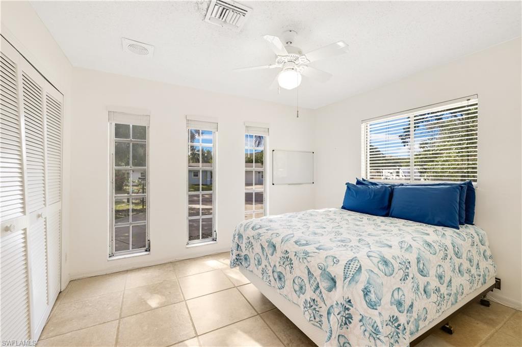 3461 Lakeview Drive Naples, FL 34112 - Photo 27 of 32 a bedroom with a large bed and a window