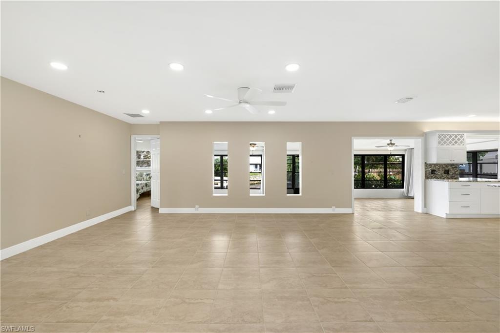 3461 Lakeview Drive Naples, FL 34112 - Photo 9 of 32 an empty room with wooden floor and windows