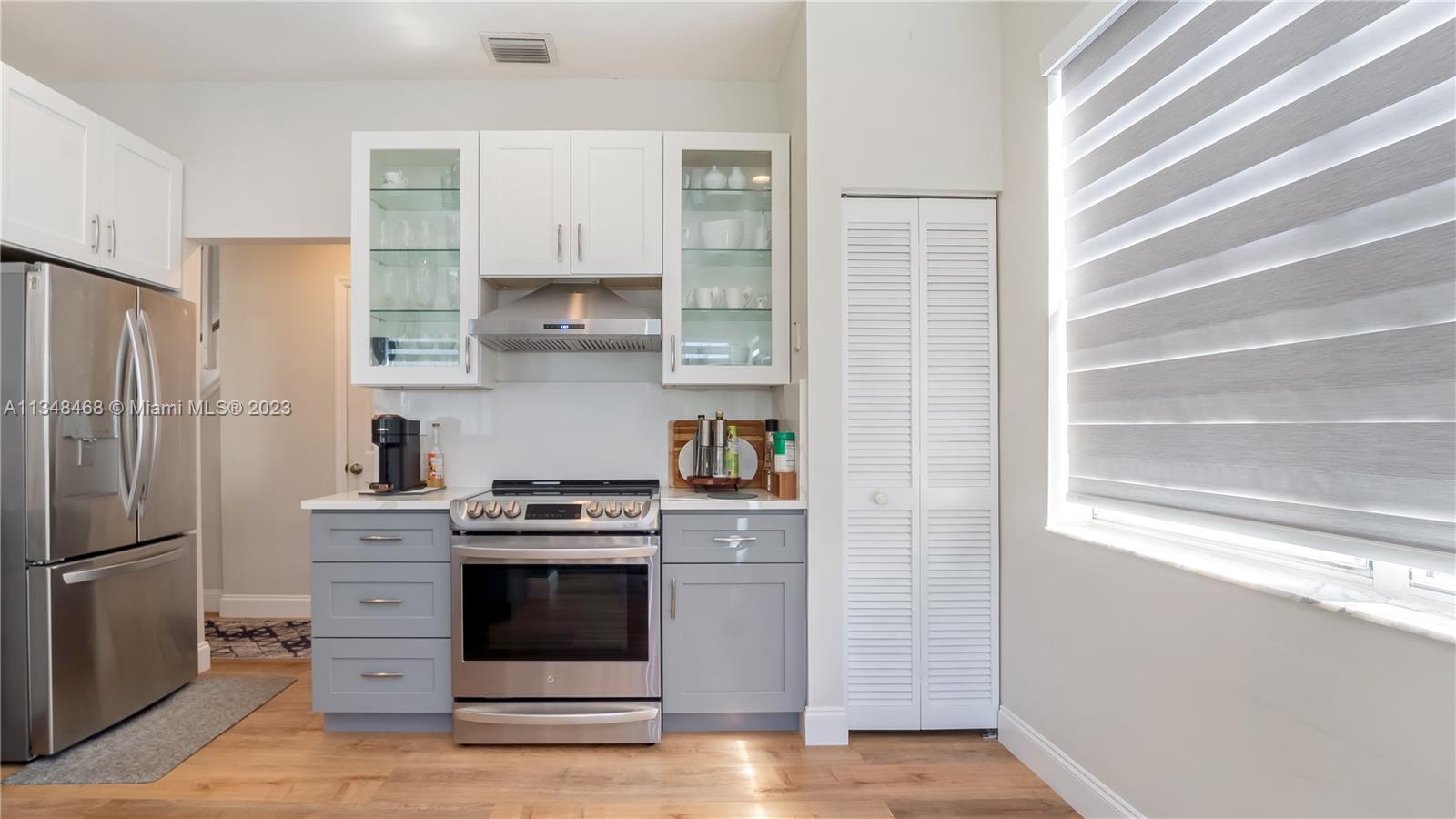675 Falling Water Road Weston, FL 33326 - Photo 18 of 39 a kitchen with white cabinets and stainless steel appliances