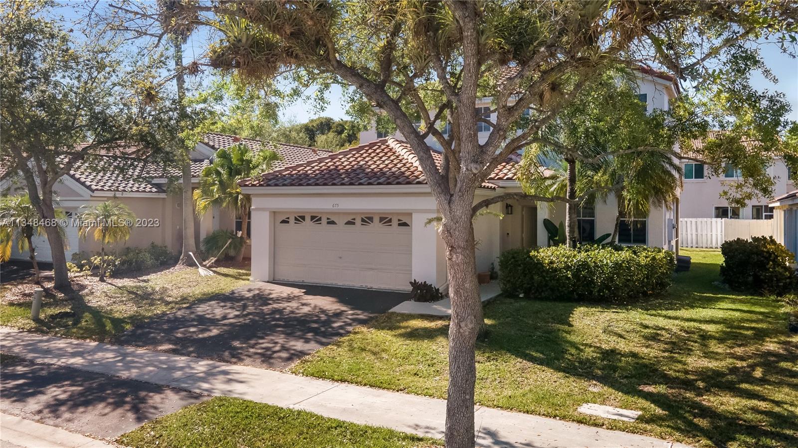 675 Falling Water Road Weston, FL 33326 - Photo 2 of 39 a front view of a house with garden