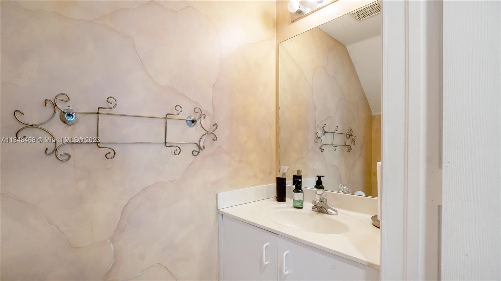675 Falling Water Road Weston, FL 33326 - Photo 27 of 39 a bathroom with a sink and mirror