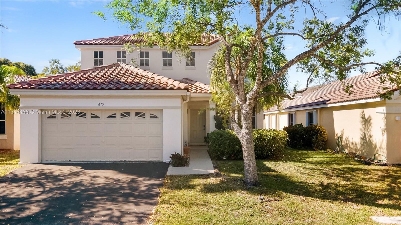 675 Falling Water Road Weston, FL 33326 - Photo 3 of 39 a front view of a house with garden