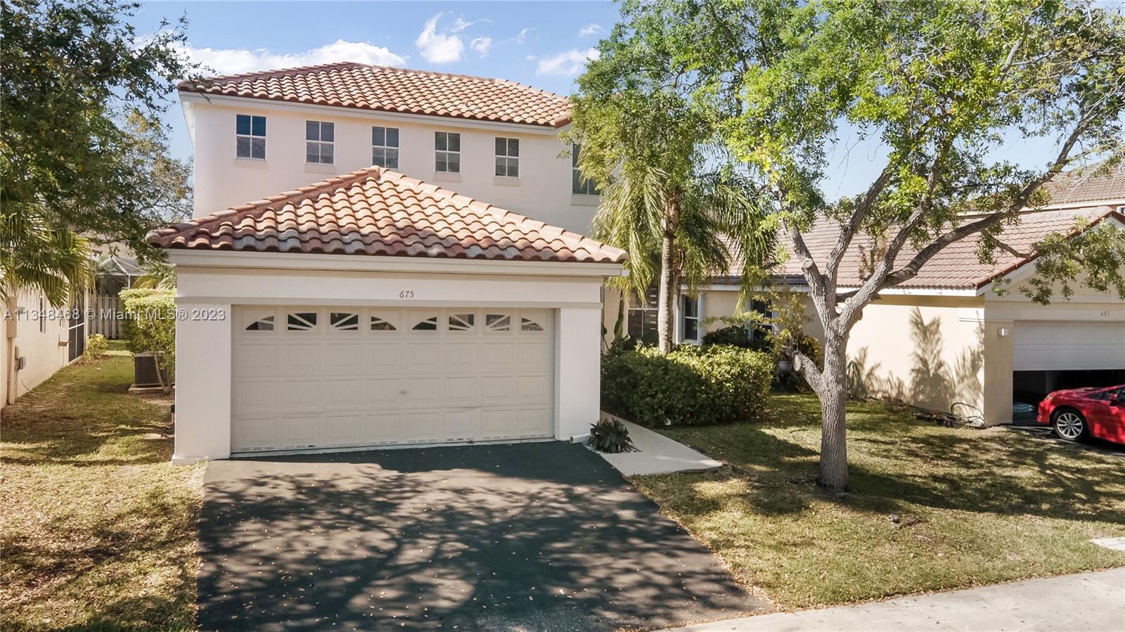 675 Falling Water Road Weston, FL 33326 - Photo 4 of 39 a front view of a house with a yard and garage