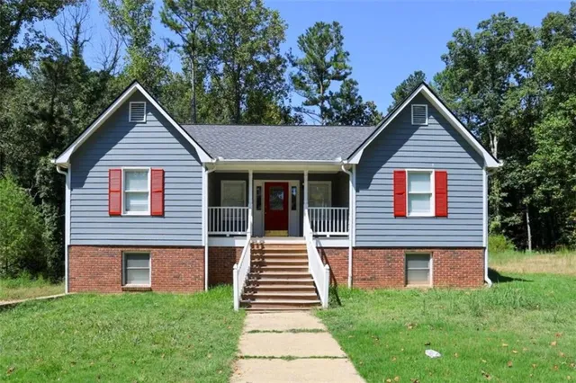 a front view of a house with a yard and trees