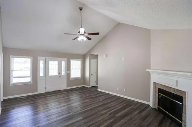 a view of an empty room with a fireplace and a window