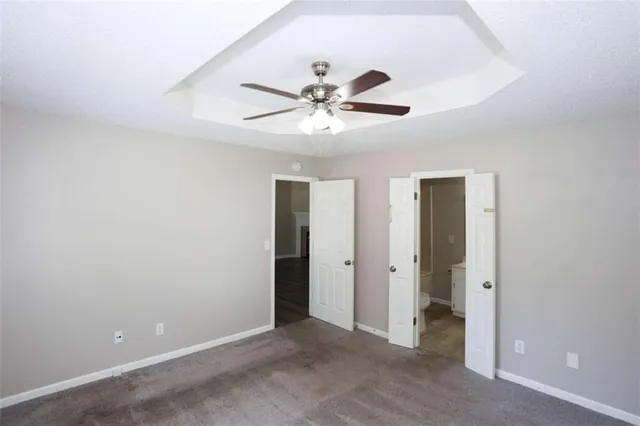 an empty room with closet and a ceiling fan