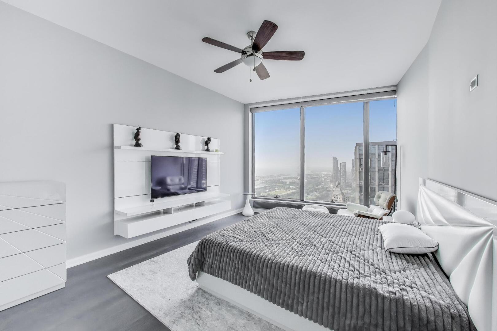 60 East Monroe Street, Unit 5103 Chicago, IL 60603 - Photo 20 of 63 a bedroom with a bed and a ceiling fan