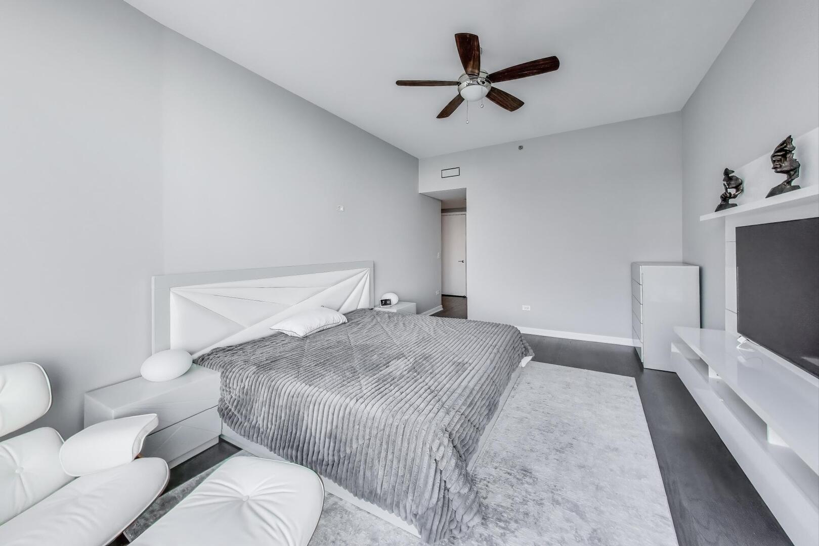 60 East Monroe Street, Unit 5103 Chicago, IL 60603 - Photo 22 of 63 a bedroom with a bed and a ceiling fan