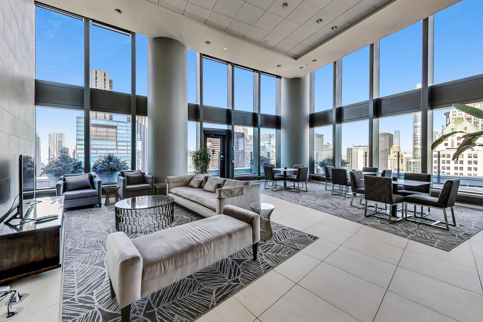 60 East Monroe Street, Unit 5103 Chicago, IL 60603 - Photo 36 of 63 a living room with couches a fireplace kitchen view and large windows