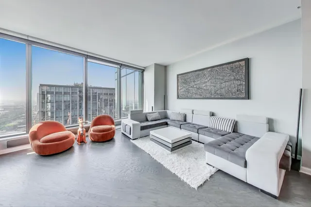 a living room with furniture wooden floor and a large window