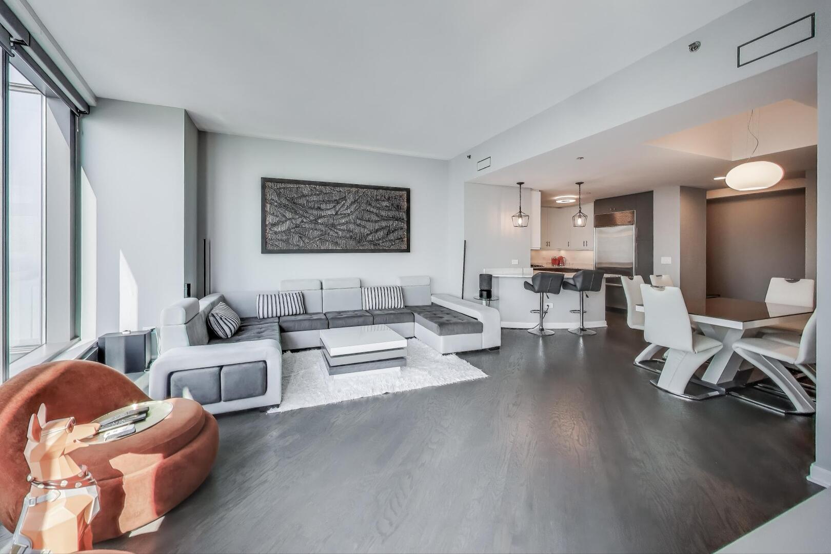 60 East Monroe Street, Unit 5103 Chicago, IL 60603 - Photo 8 of 63 a living room with furniture wooden floor and a large window