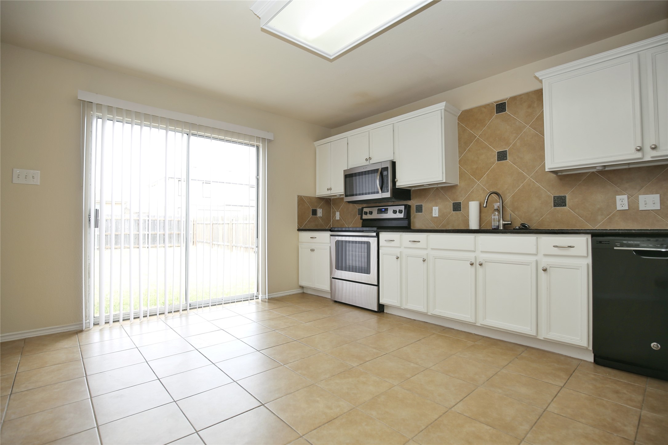 213 Rim Rock Drive Leander, TX 78641 - Photo 9 of 21 a kitchen with stainless steel appliances a sink a stove a microwave and cabinets