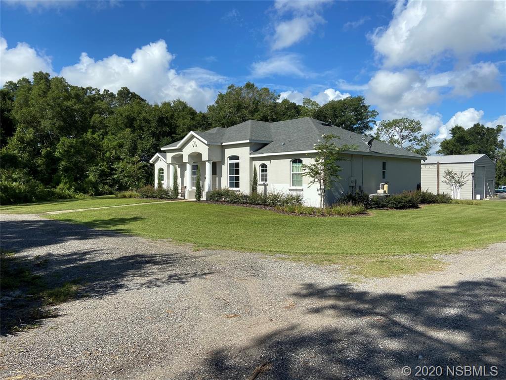 1900 Marsh Road DeLand, FL 32724 - Photo 3 of 39 a front view of a house with a garden and trees