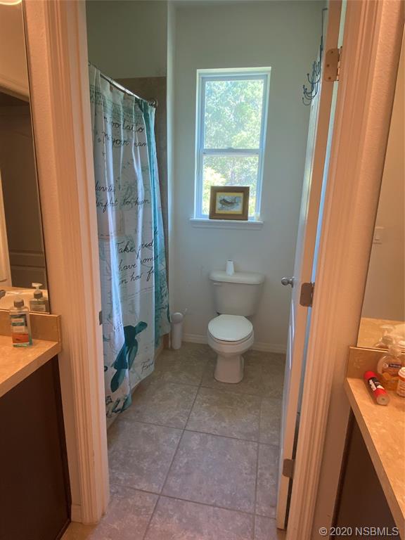 1900 Marsh Road DeLand, FL 32724 - Photo 21 of 39 a spacious bathroom with a toilet a sink and a mirror
