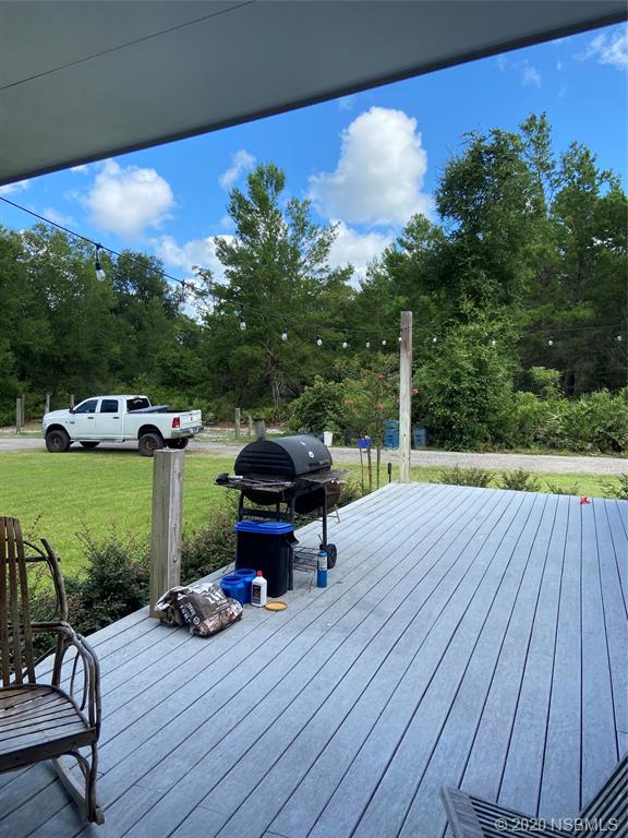 1900 Marsh Road DeLand, FL 32724 - Photo 34 of 39 a view of a chairs and table on the wooden deck
