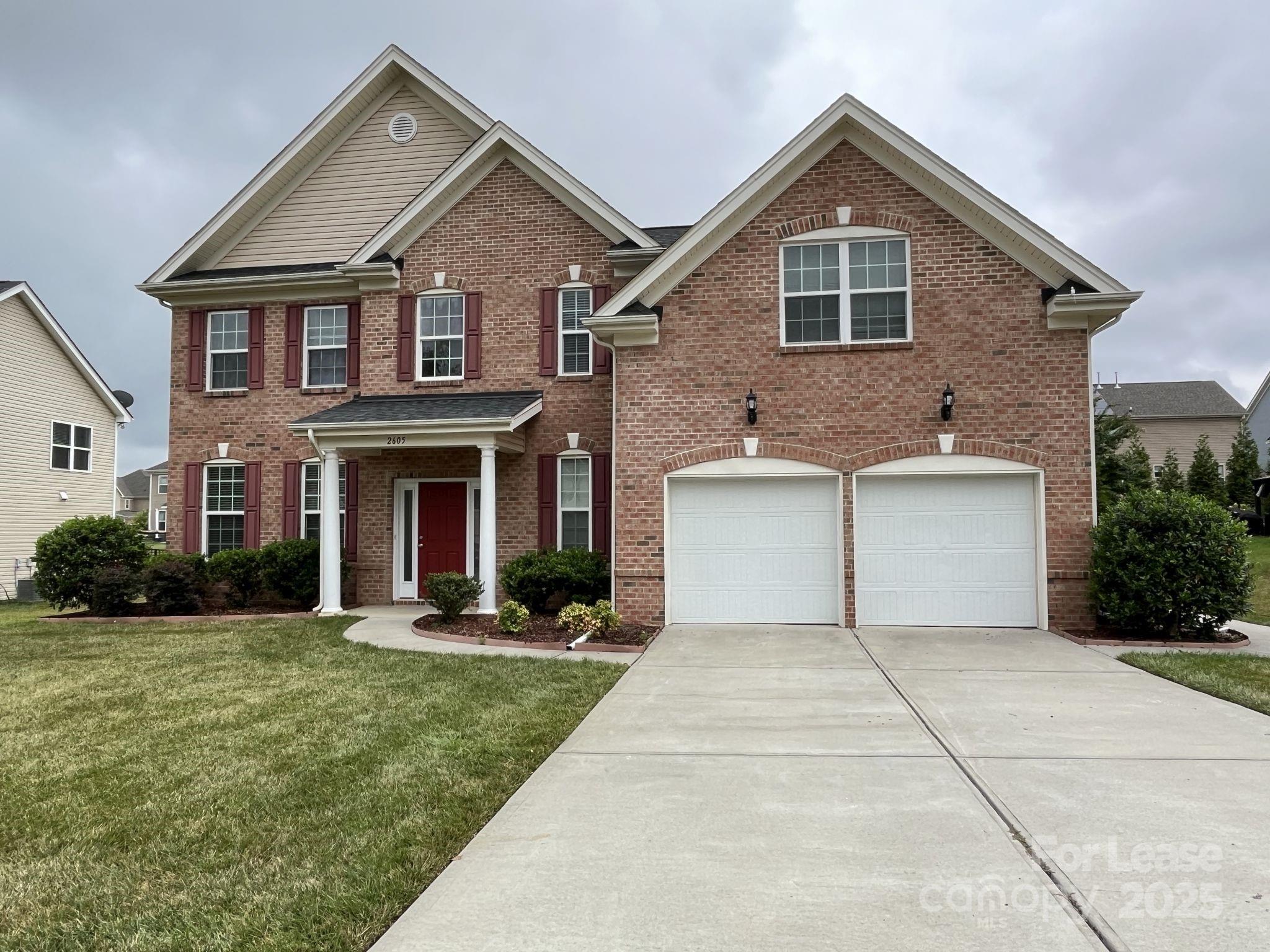 a front view of a house with a yard and garage