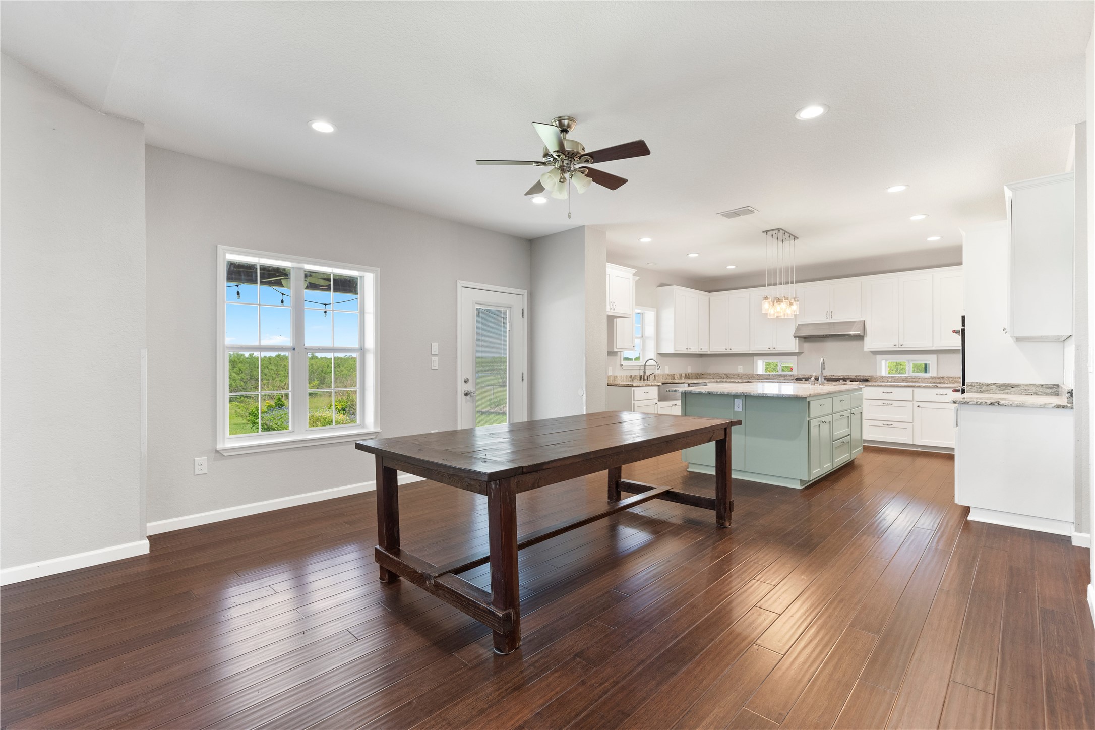 1293 Pioneer Road Seguin, TX 78155 - Photo 9 of 40 An open-concept living area boasts rich hardwood floors and an inviting kitchen island.