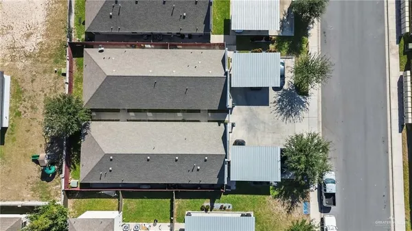 an aerial view of a house with a yard and large tree