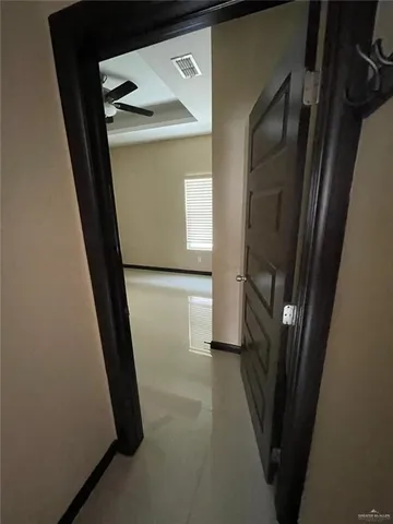 an empty room with a ceiling fan and a window