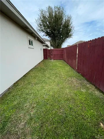 a view of backyard with wooden fence and large trees