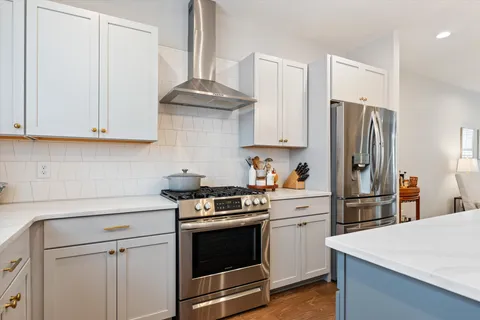 a kitchen with stainless steel appliances a stove a refrigerator and cabinets