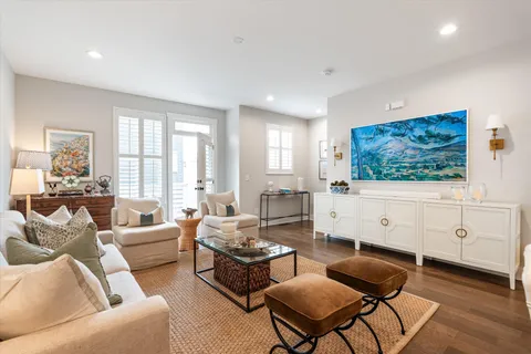 a living room with furniture a flat screen tv and a large window