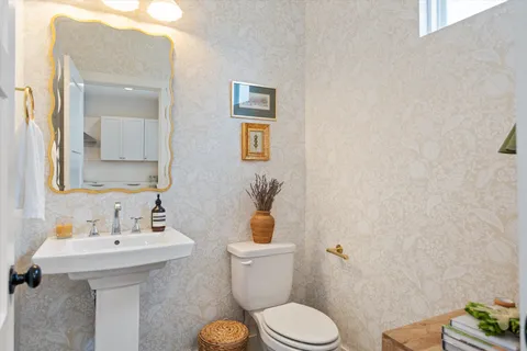 a bathroom with a sink mirror and toilet