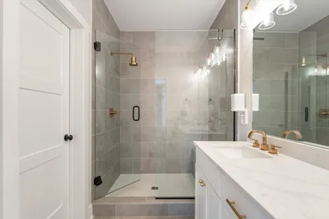 a bathroom with a sink shower and a mirror