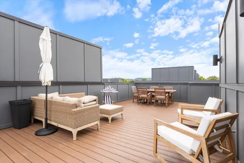 a living room with patio furniture and a potted plant