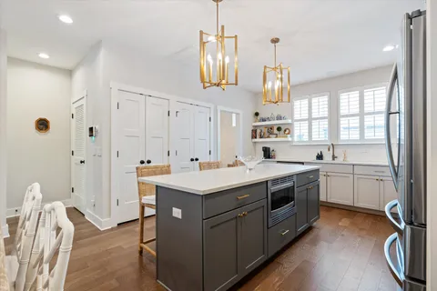 a kitchen with a sink stove and wooden floor
