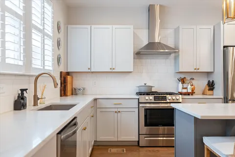 a kitchen with cabinets appliances a sink and a counter space