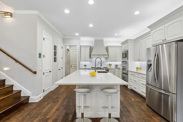 a kitchen with kitchen island a sink appliances and cabinets