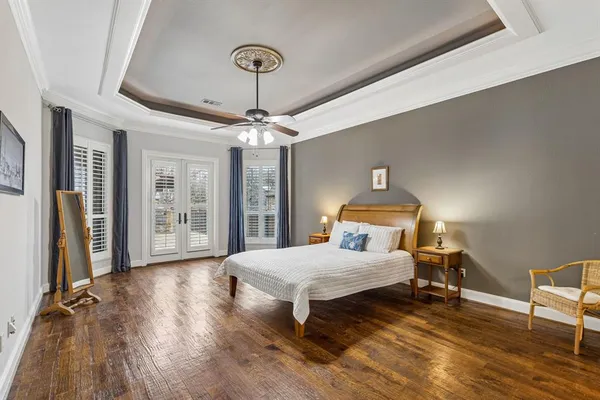 a bedroom with a bed and wooden floor