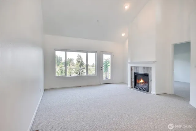 a view of empty room with a fireplace and window