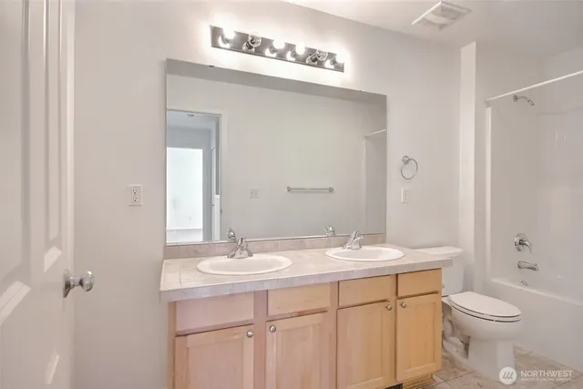 a bathroom with a sink a toilet a shower and a mirror