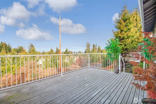 a view of a balcony with wooden floor & fence