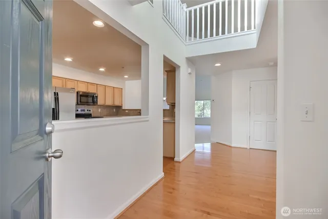 a view of a kitchen with refrigerator and white cabinets