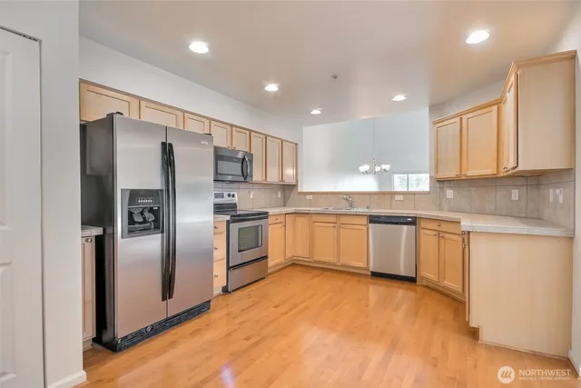 a large kitchen with cabinets stainless steel appliances and a counter