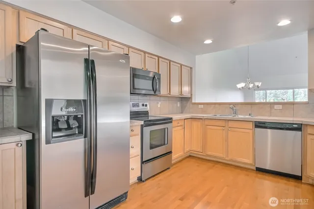 a kitchen with granite countertop stainless steel appliances a sink and counter space