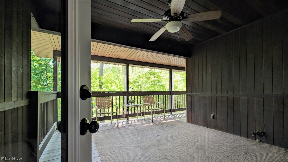6409 Old Woods Road Ashtabula, OH 44004 - Photo 8 of 43 Screened porch with a wood-finish ceiling, dark wood-paneled walls, and a ceiling fan