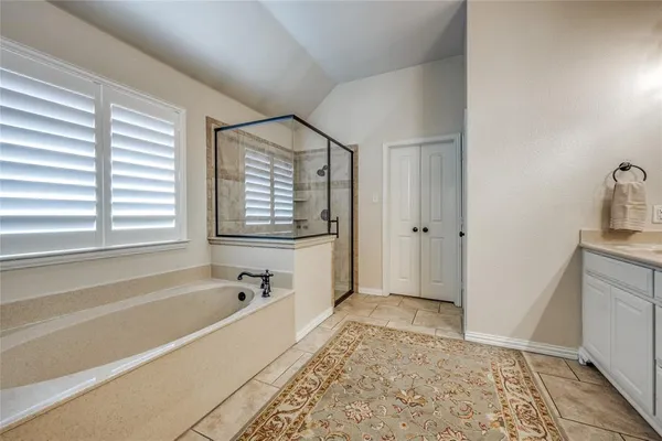 a spacious bathroom with a tub sink and mirror