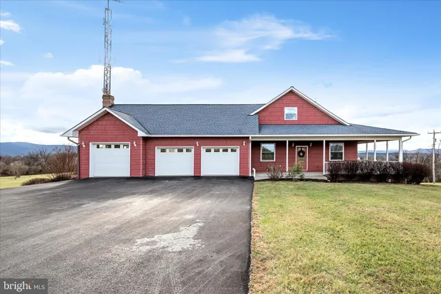 a view of a house next to a big yard with large tree