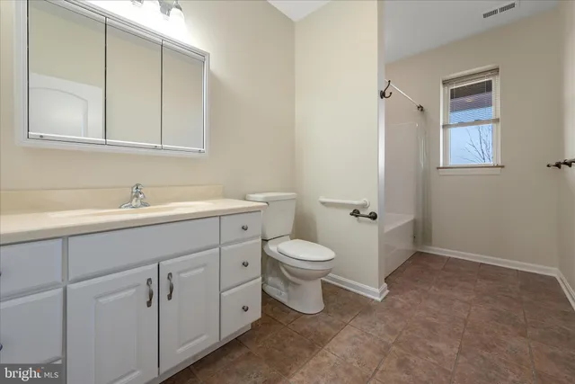 a view of a lake with lawn chairs and large trees