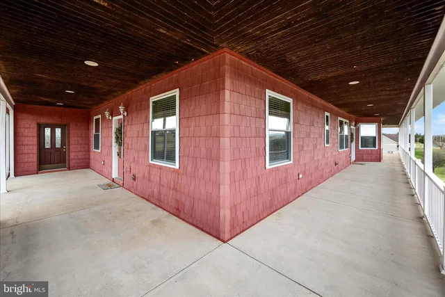 a view of a hallway with wooden floor and a room