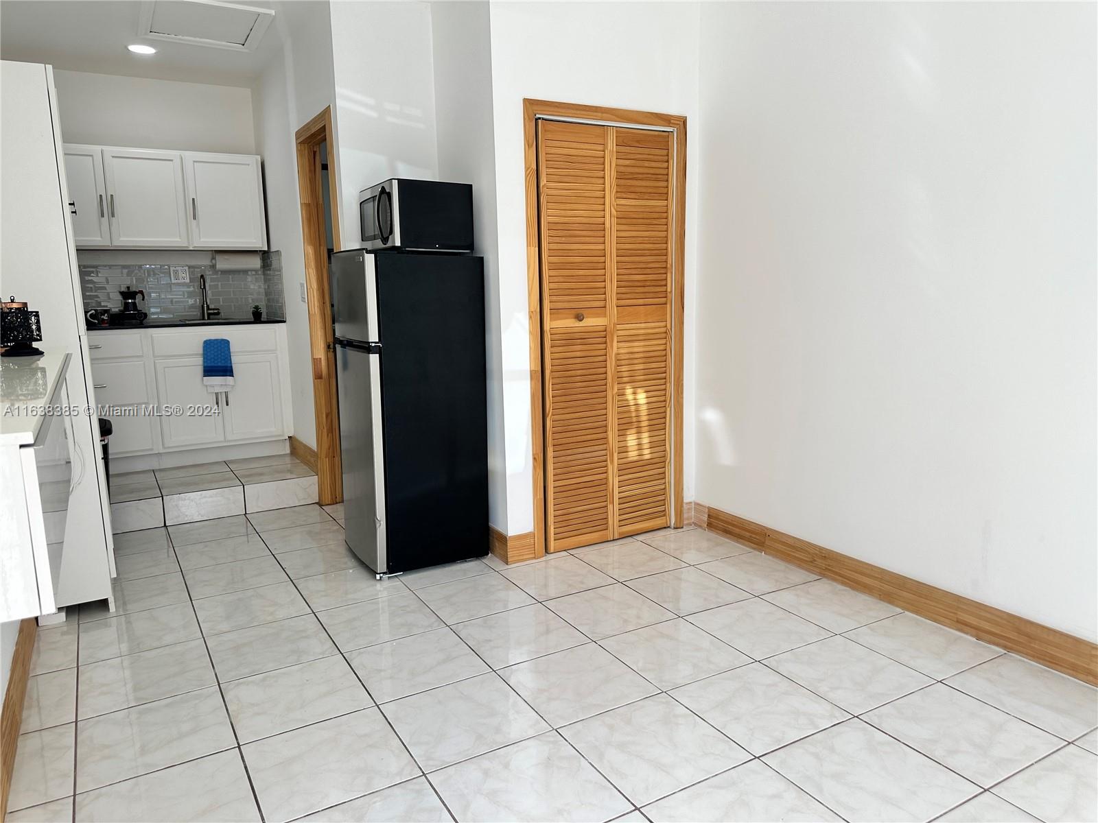 15501 Southwest 143rd Avenue, Unit 15501 Miami, FL 33177 - Photo 7 of 11 a view of a refrigerator and cabinets