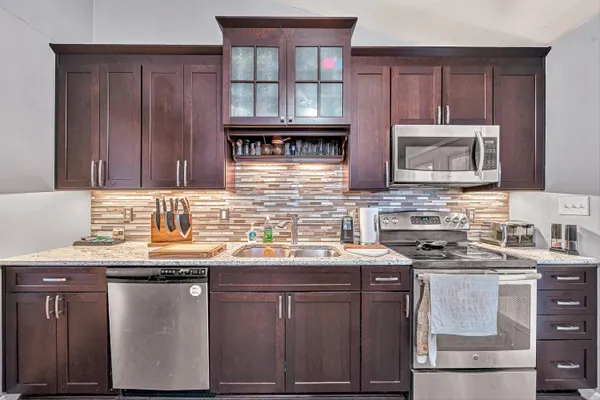 a kitchen with stainless steel appliances granite countertop a sink stove microwave and cabinets