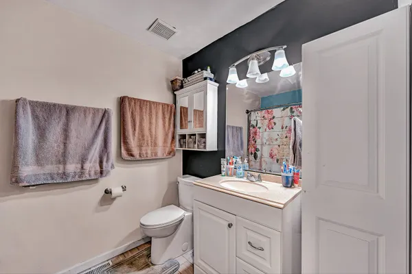 a bathroom with a sink vanity mirror and toilet