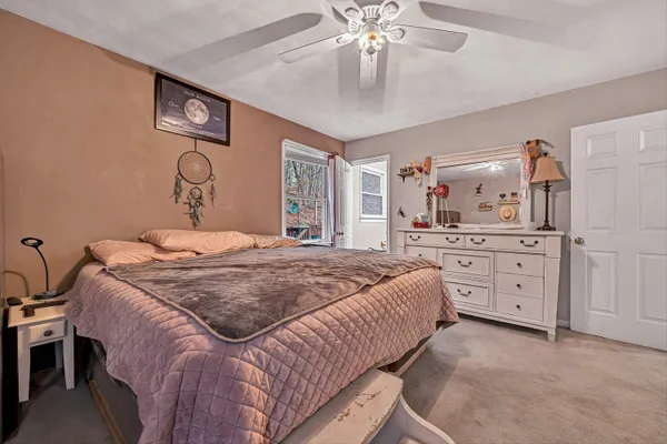 a bedroom with a large bed and a chandelier