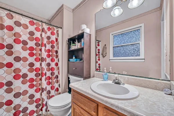 a bathroom with a sink toilet mirror and shower